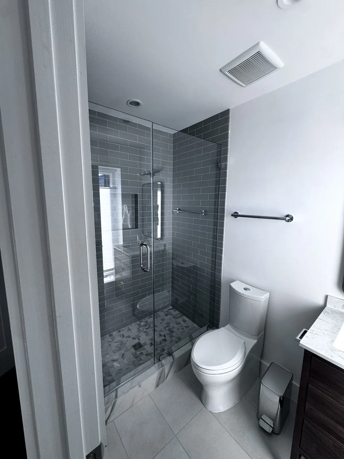Toilet area beside the glass-enclosed shower