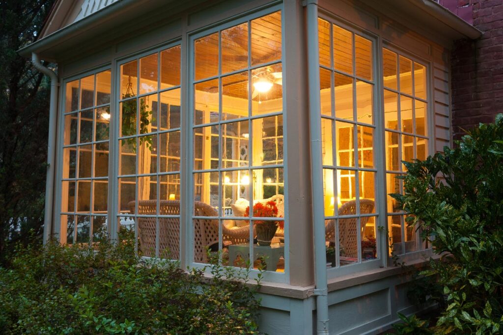 Cozy sunroom with wicker furniture and lush greenery outside