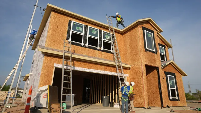 House under construction with workers and tools