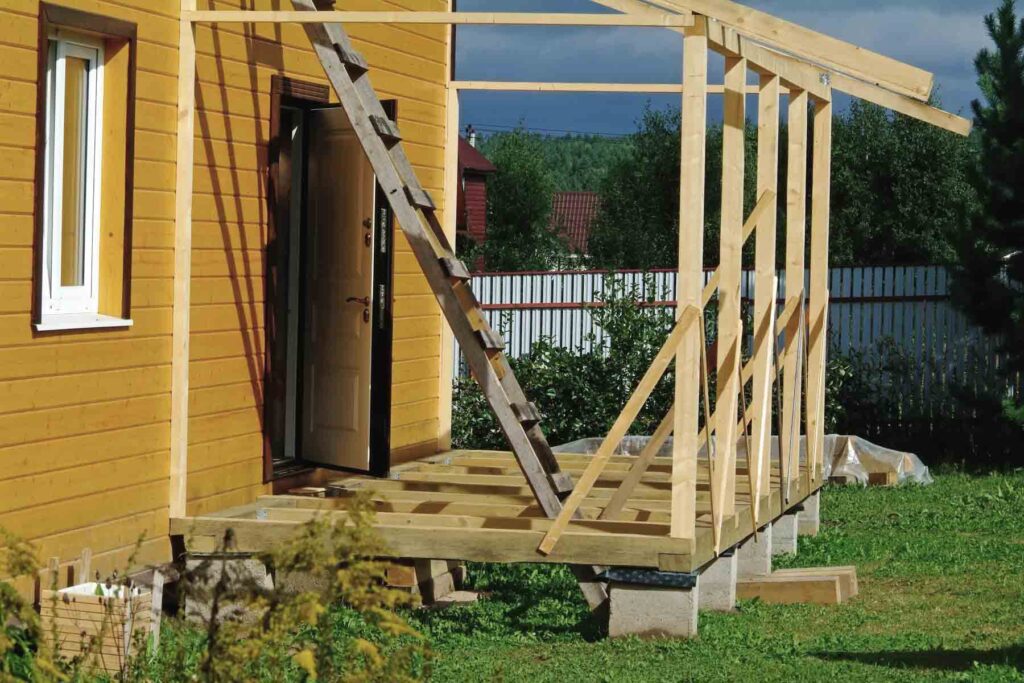 Wooden porch in progress at yellow house