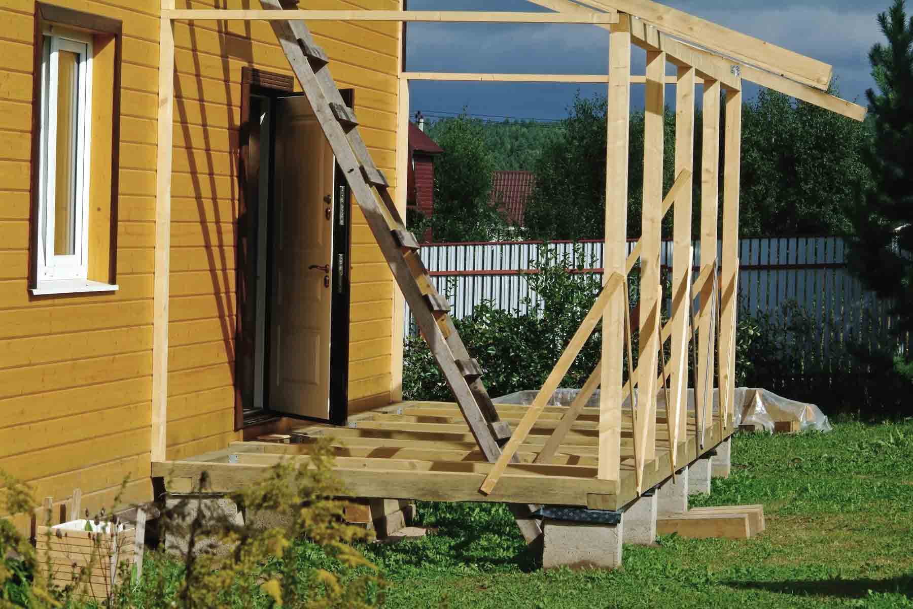 Wooden porch in progress at yellow house