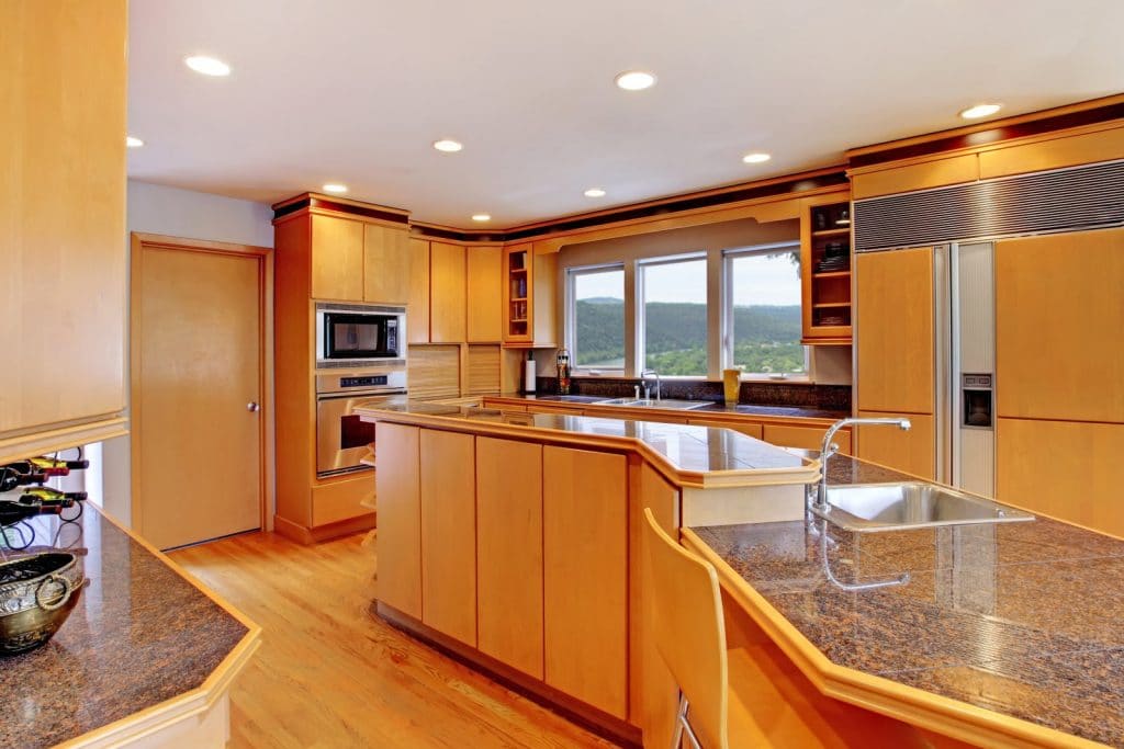 Spacious kitchen with light wood cabinets and granite countertops