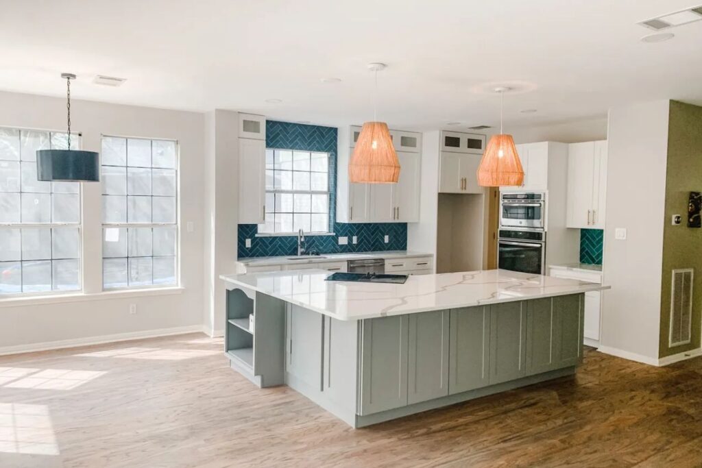 Contemporary kitchen with marble island and teal backsplash